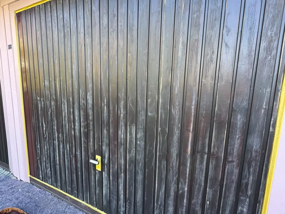 Verwitterte Garagentore mit ausgeblichenem Holz vor der Aufarbeitung