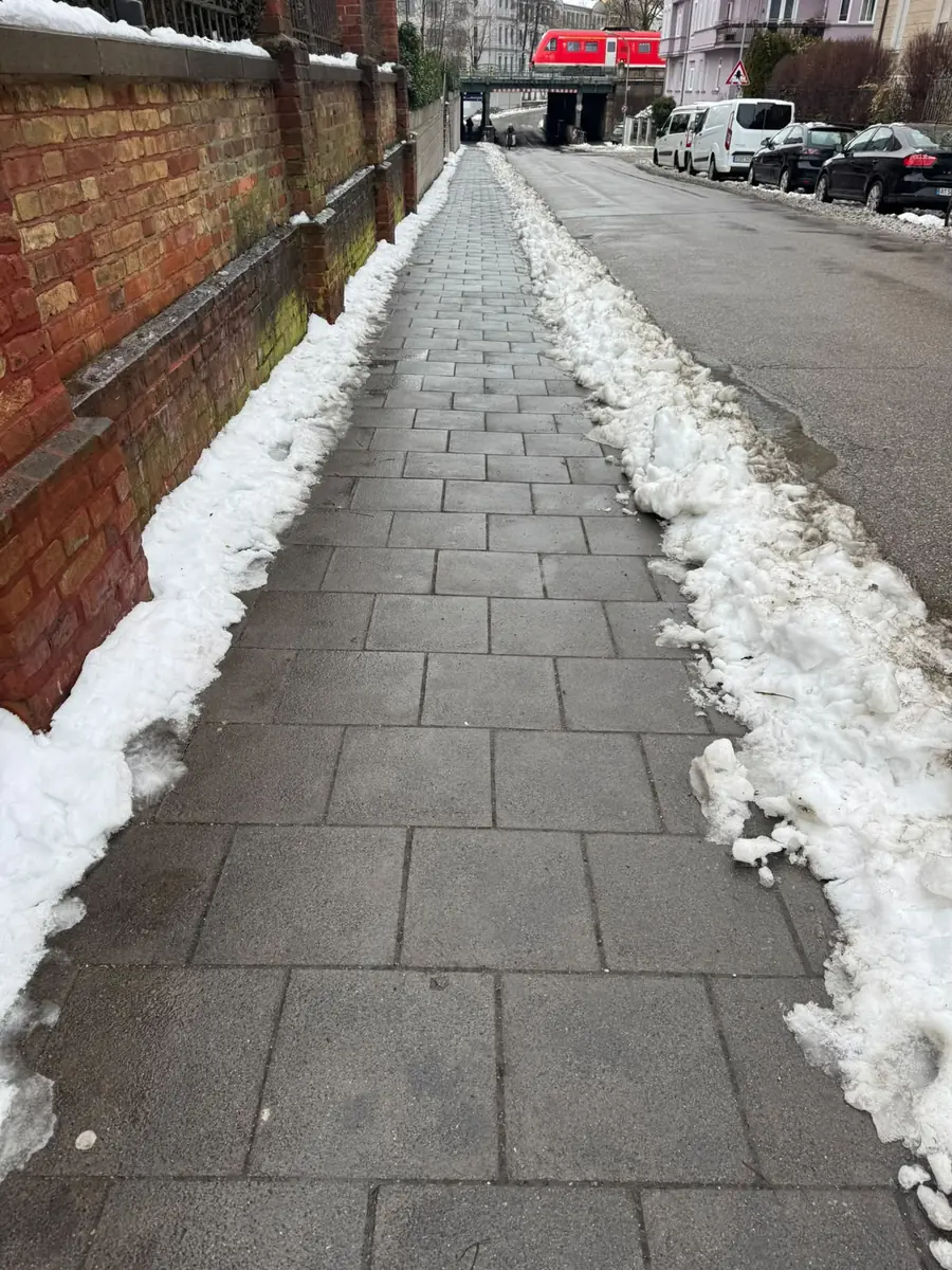 Geräumter Gehweg zwischen zwei Schneewällen