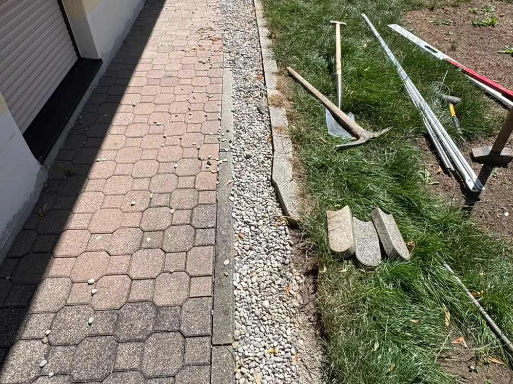 Randarbeiten an einem Pflasterweg neben einer Rasenkante