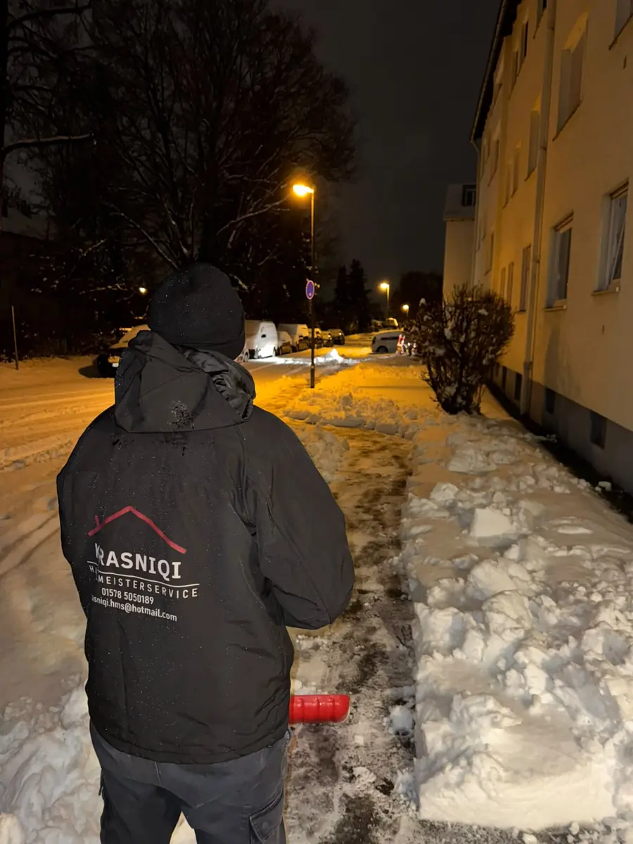 Mitarbeiter von Hausmeisterservice Krasniqi beim Streuen eines Gehwegs