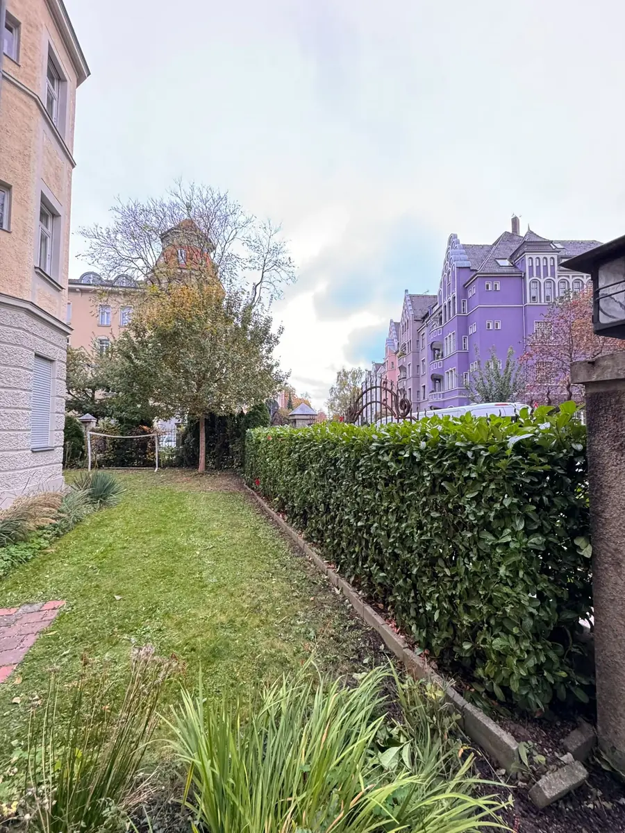 Gepflegter Innenhof einer Wohnanlage mit Rasenfläche und geschnittener Hecke